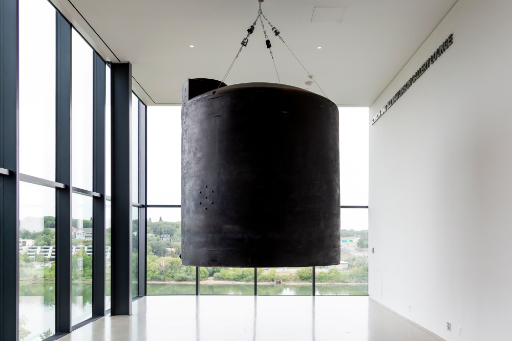 2,200-gallon polyethylene hazmat chemical storage container hanging in museum