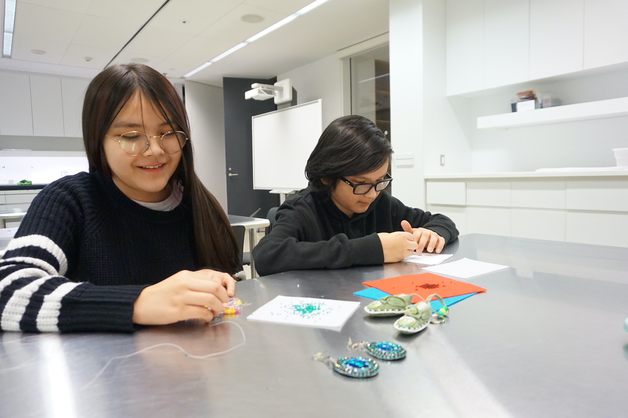 Children make beadwork at Remai Modern.