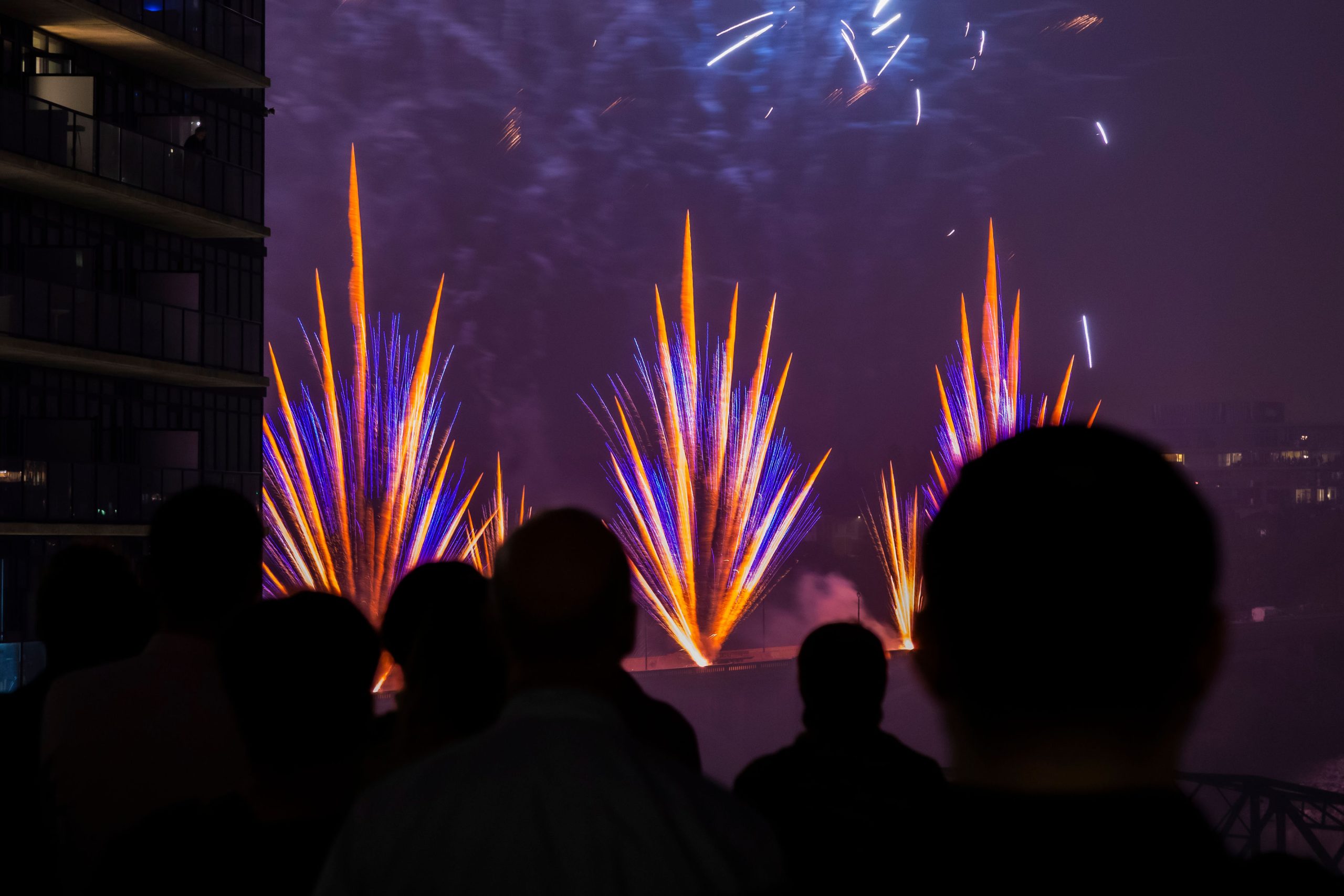 A group of people watch fireworks from Remai Modern's balcony