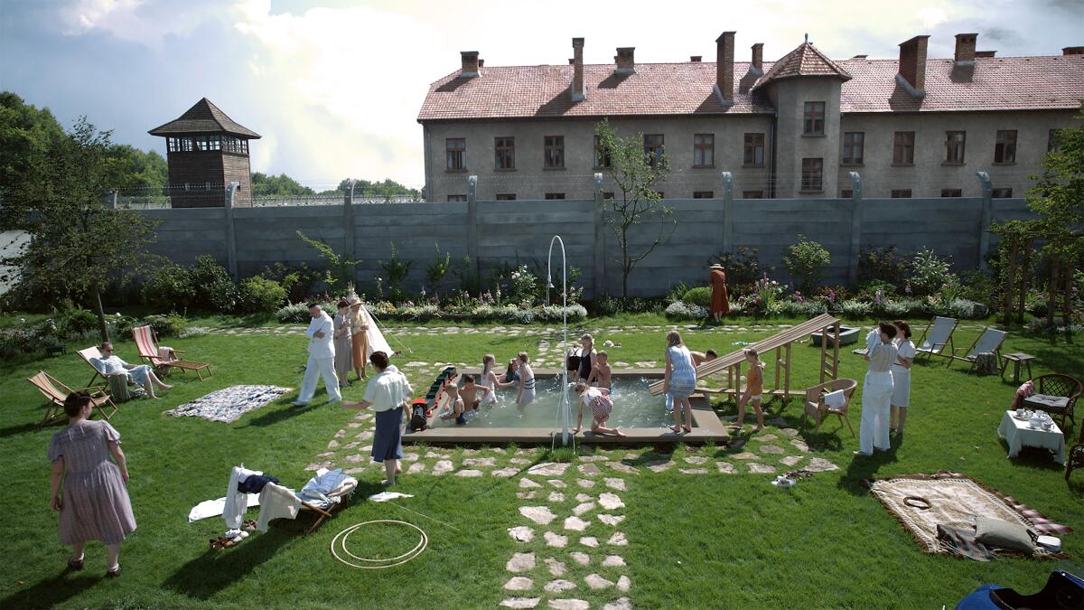 "People enjoying a sunny day in a garden with a small pool"