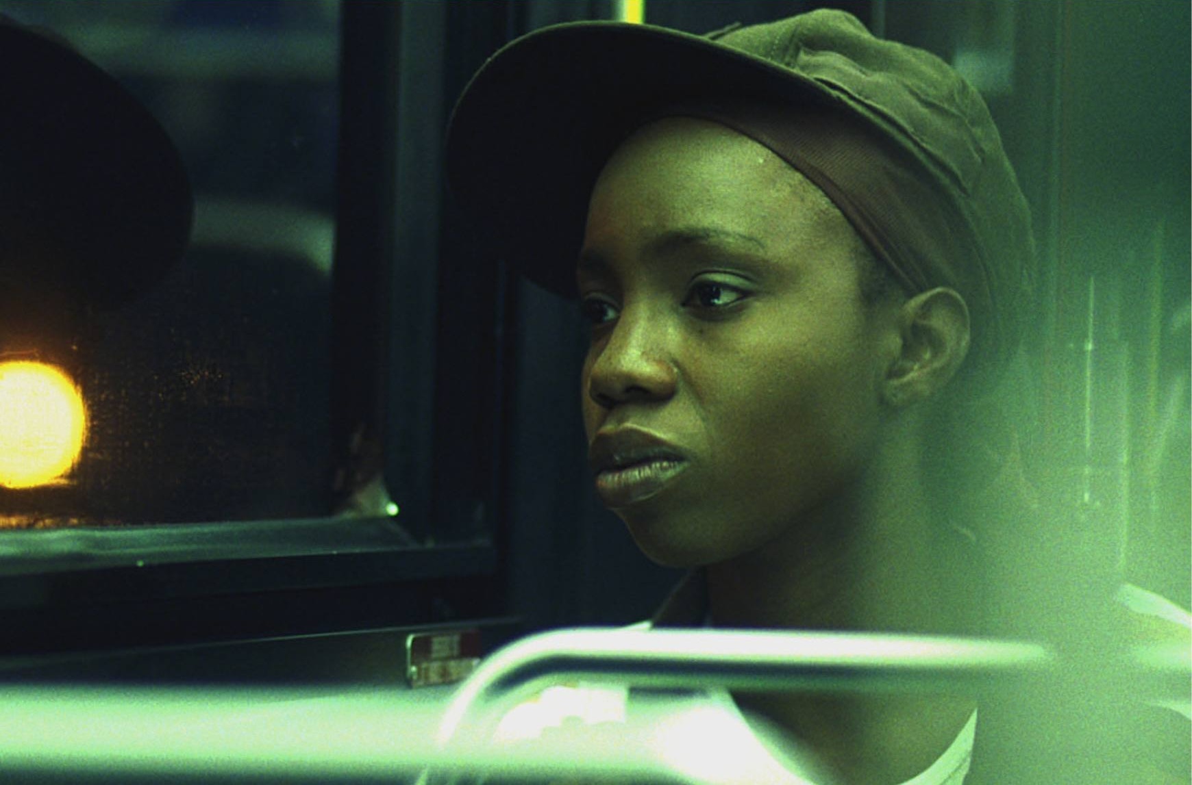 A woman wearing a stylish hat, exuding elegance and confidence in her demeanor as she sits on a bus.