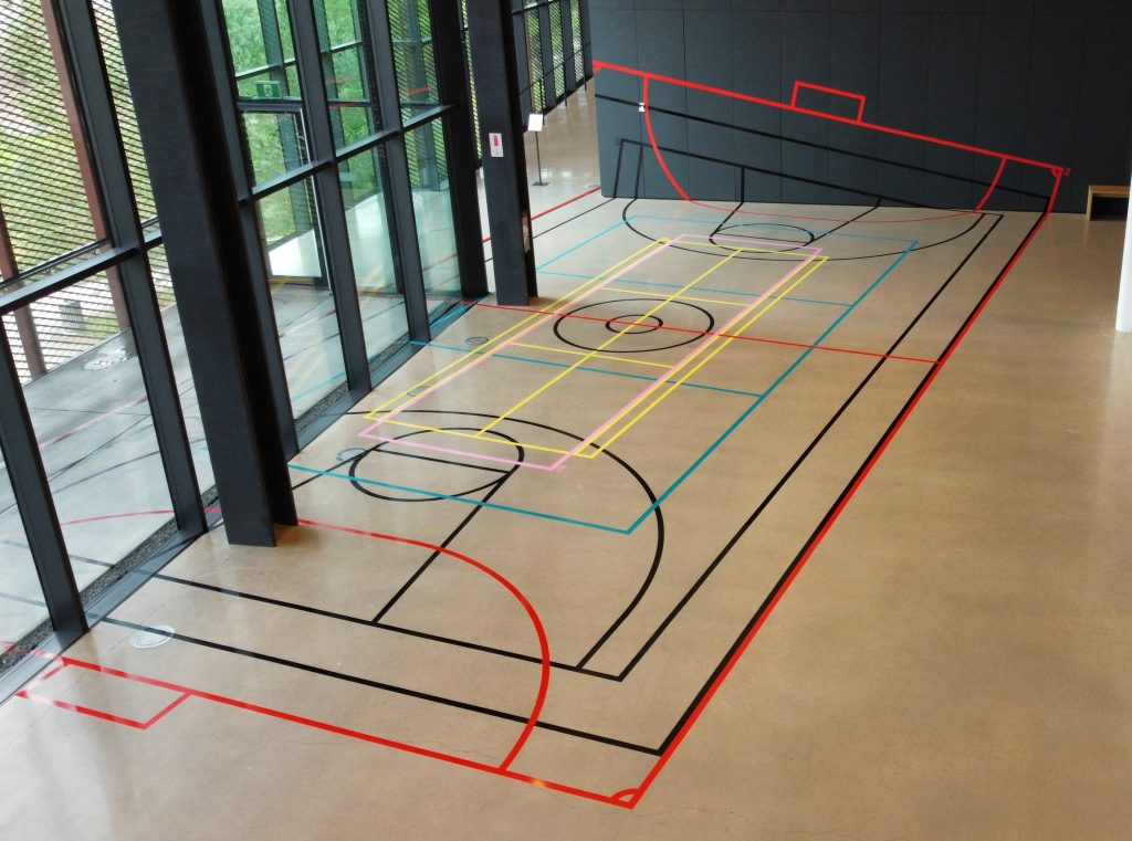 A serie of indoor sports courts are laid out, showcasing distinct line drawns on the floor for player guidance.